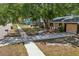 Charming single-story home featuring a well-maintained lawn, large shade trees, and neutral-toned exterior at 4468 Maraldo Ave, North Port, FL 34287