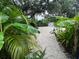 Lush backyard featuring a white gravel path, tropical plants, and a storage shed at 4695 86Th N Ave, Pinellas Park, FL 33782