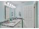 Bright bathroom with granite countertops, a large framed mirror, and brushed nickel fixtures at 4695 86Th N Ave, Pinellas Park, FL 33782