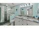 Modern bathroom with tiled shower stall and double vanity with granite countertops, and brushed nickel hardware at 4695 86Th N Ave, Pinellas Park, FL 33782