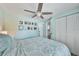 Cozy bedroom with a ceiling fan and double closet doors, adorned with Gathering photos above the bed at 4695 86Th N Ave, Pinellas Park, FL 33782