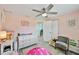 Charming bedroom with pink walls, soft lighting, and a glimpse into other parts of the home at 4695 86Th N Ave, Pinellas Park, FL 33782