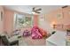 Bright bedroom with a pink color scheme, cozy decor, and lots of natural light from the window at 4695 86Th N Ave, Pinellas Park, FL 33782