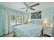 Bedroom with a ceiling fan and window with decorative curtains, and night stands with lamps at 4695 86Th N Ave, Pinellas Park, FL 33782