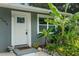 Close up view of the front entrance with tropical plants and a well-maintained white door and a storm door at 4695 86Th N Ave, Pinellas Park, FL 33782