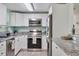 Modern kitchen featuring stainless steel appliances, granite countertops, and white cabinetry at 4695 86Th N Ave, Pinellas Park, FL 33782