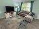 Inviting living room features a grey sectional sofa, entertainment center, and bright window at 4695 86Th N Ave, Pinellas Park, FL 33782