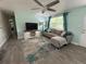 Cozy living room with a grey sectional sofa and a ceiling fan for comfortable living at 4695 86Th N Ave, Pinellas Park, FL 33782