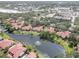 Expansive aerial view captures a community with a pond, commercial buildings and the surrounding neighborhood at 5039 Kestral Park Dr # 67, Sarasota, FL 34231