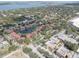 An elevated view shows a community surrounded by lush greenery, a peaceful pond, and commercial buildings at 5039 Kestral Park Dr # 67, Sarasota, FL 34231