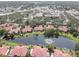 Aerial view of a beautiful community with red tile roofs, a pond with a fountain, and commercial buildings at 5039 Kestral Park Dr # 67, Sarasota, FL 34231