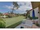 Private backyard featuring an outside seating area, expansive lawn, and waterway beyond at 5039 Kestral Park Dr # 67, Sarasota, FL 34231