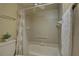 Neutral bathroom with a tub and shower combination, featuring tiled walls and a grab bar for safety at 5039 Kestral Park Dr # 67, Sarasota, FL 34231