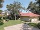 Charming home exterior boasting a lush front yard, red tile roof, and convenient two-car garage at 5039 Kestral Park Dr # 67, Sarasota, FL 34231