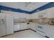 Well-lit kitchen featuring white appliances, tile flooring, and ample cabinet space at 5039 Kestral Park Dr # 67, Sarasota, FL 34231