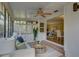 Cozy sunroom living area with comfortable seating, ceiling fan, and seamless access to the dining area at 5039 Kestral Park Dr # 67, Sarasota, FL 34231