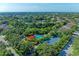 Expansive aerial view of a lush community featuring a pool, tennis courts, and serene lake views at 5386 Creekside Trl, Sarasota, FL 34243