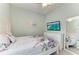 Bright bedroom features a ceiling fan, wall-mounted TV, and mirror at 5386 Creekside Trl, Sarasota, FL 34243