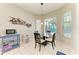 Cozy breakfast nook with a glass table set, bright windows, and decorative fish wall art at 5386 Creekside Trl, Sarasota, FL 34243