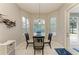 Bright breakfast nook showcasing a glass table, three sunny windows, and direct access to the pool at 5386 Creekside Trl, Sarasota, FL 34243