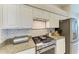 Kitchen features stainless steel appliances, granite countertops, and white cabinetry, for a bright space at 5386 Creekside Trl, Sarasota, FL 34243