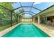 Long, screened-in pool with brick surround, adjacent to patio with chairs at 5386 Creekside Trl, Sarasota, FL 34243