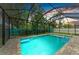 Inviting screened-in pool with brick surround and lush landscaping for privacy at 5386 Creekside Trl, Sarasota, FL 34243