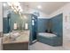 Charming bathroom featuring custom tilework in blue, a soaking tub, and a vanity with granite countertop at 5403 2Nd W Ave, Bradenton, FL 34209