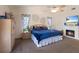 Main bedroom featuring a ceiling fan, a fireplace, and large windows with curtains at 5403 2Nd W Ave, Bradenton, FL 34209