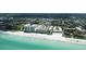 Amazing aerial view overlooking the pristine white beach, turquoise ocean, and surrounding buildings at 5623 Midnight Pass Rd # 615, Sarasota, FL 34242