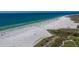 Expansive aerial view of a white sand beach with turquoise water and people enjoying a sunny day on the shore at 5623 Midnight Pass Rd # 615, Sarasota, FL 34242