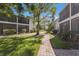 Beautiful courtyard with brick pathway, green lawn, mature trees, and manicured bushes at 5623 Midnight Pass Rd # 615, Sarasota, FL 34242
