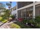Exterior view of the building showcasing screened in balcony and lush landscaping at 5623 Midnight Pass Rd # 615, Sarasota, FL 34242