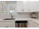 Close-up of the kitchen showing stainless appliances, white cabinets and countertop, and tile backsplash at 5623 Midnight Pass Rd # 615, Sarasota, FL 34242