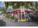Outdoor dining area of Siesta Key Oyster Bar, featuring red umbrellas, lush greenery, and a vibrant atmosphere at 5623 Midnight Pass Rd # 615, Sarasota, FL 34242