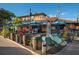 Outdoor dining space with blue umbrellas, wine barrels, and tropical foliage at 5623 Midnight Pass Rd # 615, Sarasota, FL 34242