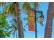 Welcoming Siesta Key Village sign on a street lamp, framed by palm trees under a clear blue sky at 5623 Midnight Pass Rd # 615, Sarasota, FL 34242