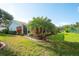 Picturesque backyard with lush lawn, mature landscaping, and a screened lanai at 5812 Garden Lakes Fern, Bradenton, FL 34203