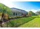 Beautiful backyard featuring lush landscaping, a screened-in lanai, and a well-manicured lawn at 5812 Garden Lakes Fern, Bradenton, FL 34203