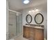 Bathroom featuring a dual sink vanity with granite countertop and a glass-enclosed shower at 5812 Garden Lakes Fern, Bradenton, FL 34203