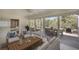 Living room has sunroom-style with white furniture and multiple sliding glass doors overlooking the backyard with table at 5812 Garden Lakes Fern, Bradenton, FL 34203