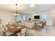 Open-concept living room and dining area with neutral tones, wood floors, and a bright, airy feel at 5812 Garden Lakes Fern, Bradenton, FL 34203
