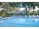 Community pool and deck area with ample seating surrounded by mature landscaping at 5812 Garden Lakes Fern, Bradenton, FL 34203