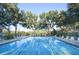 Expansive community swimming pool with plenty of seating and lush trees for shade at 5812 Garden Lakes Fern, Bradenton, FL 34203