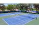 Aerial view of pristine tennis courts with lush greenery and nearby clubhouse at 5812 Garden Lakes Fern, Bradenton, FL 34203