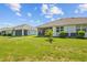 Lush backyard featuring green grass, young palm tree, and screened-in porches at 5816 Mezzana Run, Palmetto, FL 34221