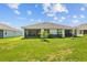 Backyard view with lush grass, young palm tree, and a screened-in lanai at 5816 Mezzana Run, Palmetto, FL 34221