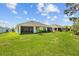 Backyard view featuring lush green grass and screened-in porch at 5816 Mezzana Run, Palmetto, FL 34221