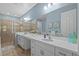 Bright bathroom featuring a dual vanity with white countertops and a tiled shower at 5816 Mezzana Run, Palmetto, FL 34221