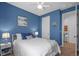 Cozy bedroom featuring blue walls, bedside tables with lamps, and wood look flooring at 5816 Mezzana Run, Palmetto, FL 34221